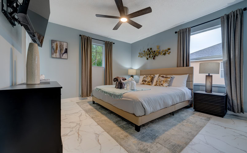 Spacious modern king bedroom with neutral decor and large windows at Marble Studios Florida in Kissimmee