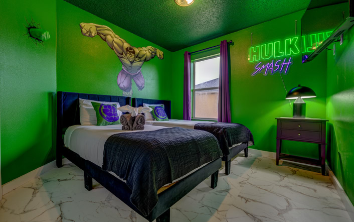 Green Hulk themed twin bedroom with neon wall art at Marble Studios Florida in Kissimmee
